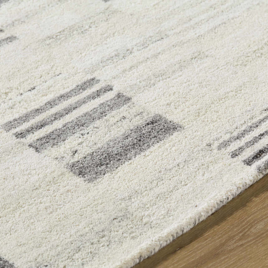 Close up of the Blaton Area Rug showing its wool texture and ash and desert sand geometric pattern. Texture