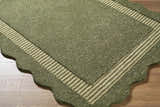 Close-up of a Wone Green Border Hand Tufted Wool Area Rug showing texture, striped border, and scalloped edge detail. Corner