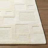 Close up of the hand-tufted Botham Area Rug. Beige, cream, and ivory wool rug with a geometric block pattern. Front