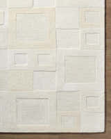 Close-up of the Botham Area Rug. Hand-tufted wool rug in a geometric square pattern, beige, cream, ivory, and tan colors. Corner
