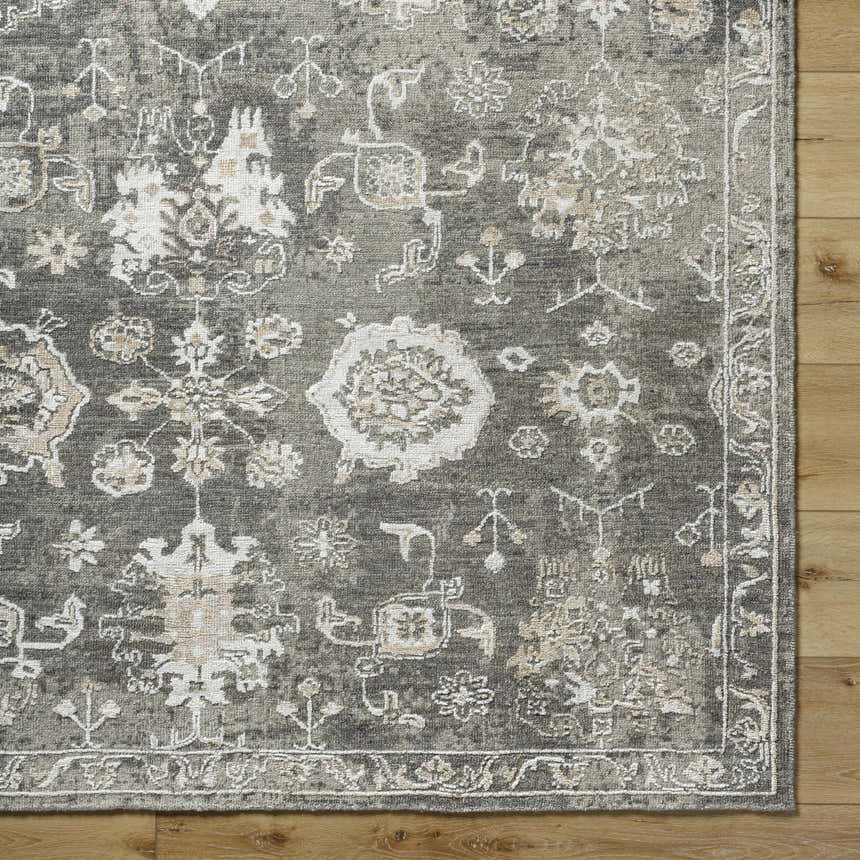 Close-up of the charcoal Cantley Handmade Wool Area Rug showing its traditional cream and beige floral pattern and hand-knotted texture. Swatch