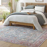 Bedroom scene with a Rust Catadupa Distressed Washable Area Rug. The rug has a blue, gray, and red vintage Persian-style design. Roomscene-Rectangle