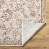 Close-up of the Chyron Cream Area Rug showing its floral pattern, cream, tan, and brown colors, and woven texture. Fold