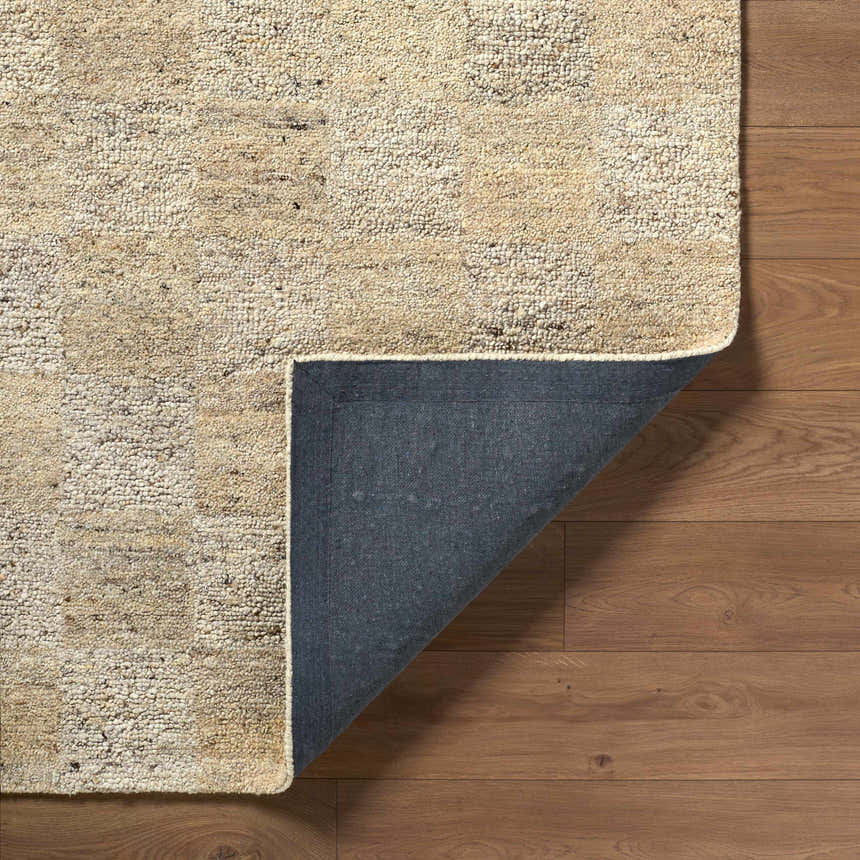 Close up of the hand tufted Chasya Sandstone Area Rug showing wool texture and backing. Colors: ivory, pebble, sandstone, taupe. Fold