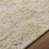 Close-up of the hand-tufted Chasya Sandstone Area Rug. Wool rug in ivory, pebble, sandstone, and taupe on wood floor. Texture
