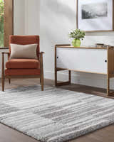 Living room scene with an orange chair and gray and ivory Carlen Gray Area Rug. Roomscene-Rectangle