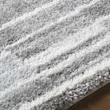 Close-up of the Carlen Gray Area Rug. Shag rug with gray and ivory horizontal stripes. Soft, textured design. Texture