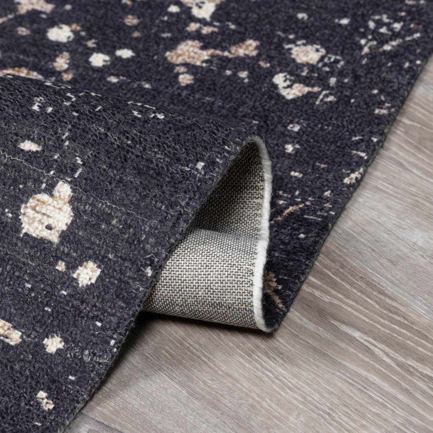 Close-up of Janek Handmade Galey Alix x LIVABLISS GAJA-2300 Area Rug. Charcoal rug with ivory and taupe abstract pattern. Fold