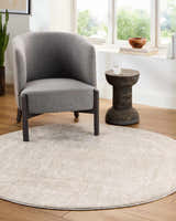 Living room scene with a round, light sage Catrin Area Rug, gray chair, and wood accent table. Roomscene-Round
