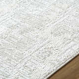 Close up of the Annisa Area Rug, showing its cream, ivory, and light gray textured design. Texture