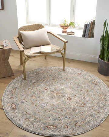 Sunlit reading nook with a round Chione Cream Area Rug, woven chair, and wood accents. Calm, inviting space. Roomscene-Round