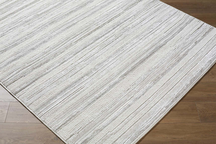 Close-up of the Cardea Area Rug showing its cream, ivory, and light gray contemporary striped design and texture. Corner