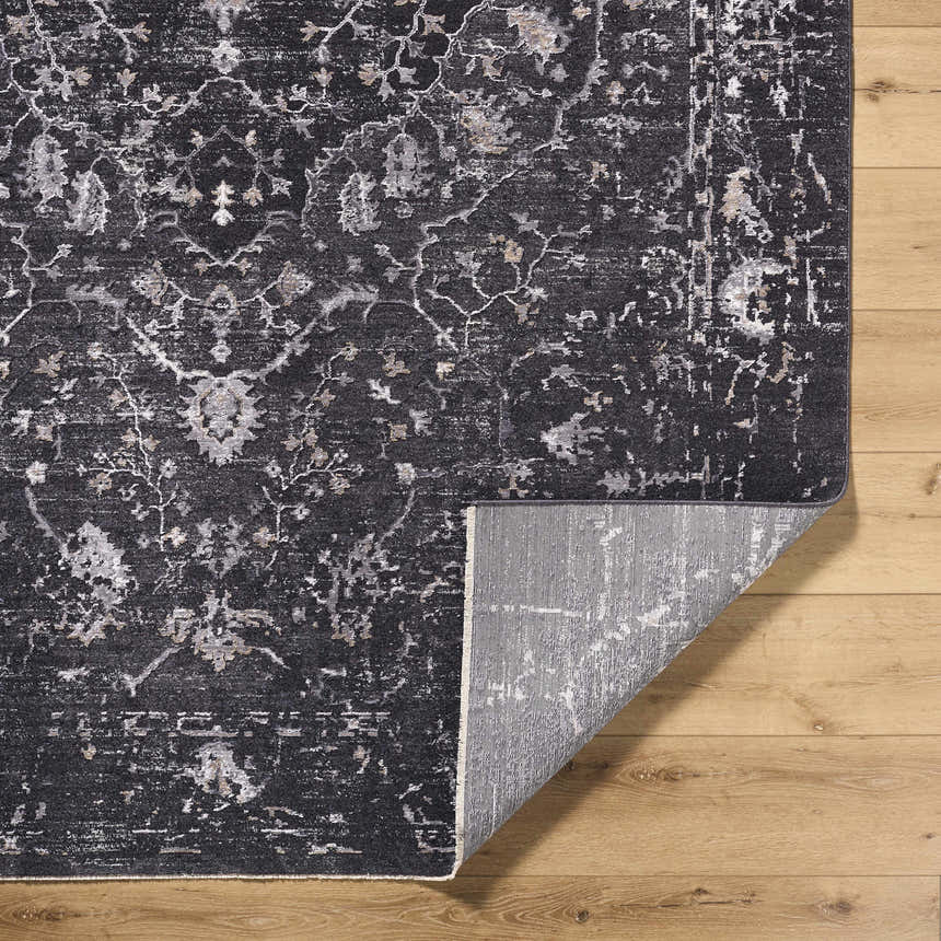Close-up of the Corina Black Area Rug showing its traditional floral pattern and gray, ivory, and charcoal colors. Fold