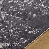 Close up of the Corina Black Area Rug showing its charcoal, gray, and ivory abstract pattern and soft texture. Texture