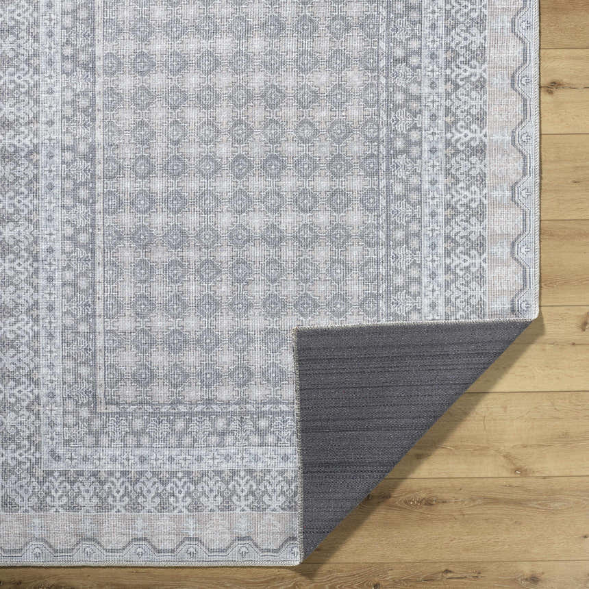 Rainier PNWRN-2313 rug close-up. Machine woven polyester rug with traditional geometric patterns in pale blue, white, and gray. Fold