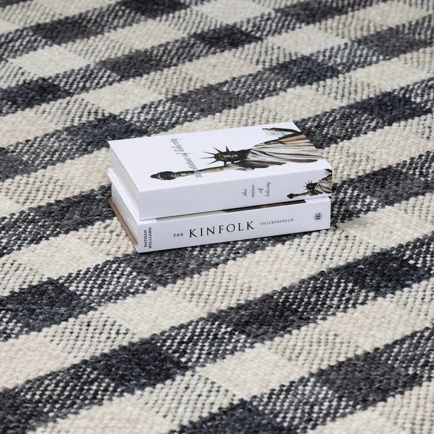 Close-up of the Chilliwack Gray Plaid Wool Rug, showing its charcoal, cream, and gray woven texture and plaid pattern. Styleshot