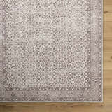 Close-up of the Spokane Machine Woven rug showing its cream and brown floral medallion pattern and traditional border. Corner