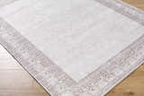 Close up of Rainier Cottage Border Brown Washable Rug showing cream, brown, and traditional border design. Corner