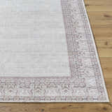 Close-up of Rainier Cottage Border Brown Washable Rug. Cream rug with dark red and slate blue traditional border pattern. Front