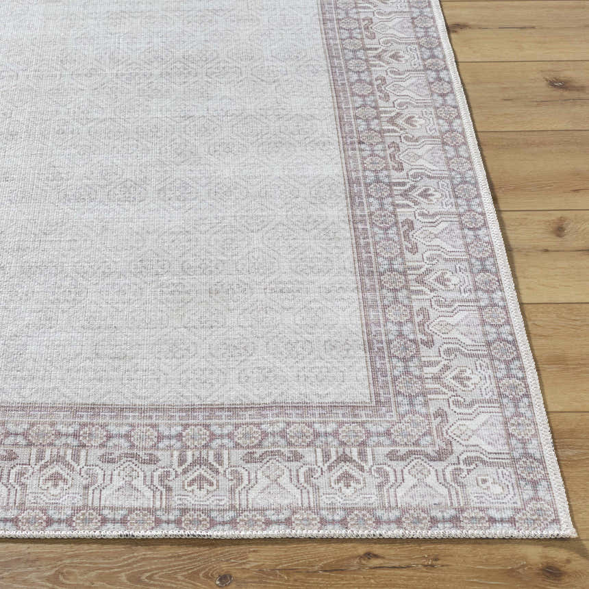 Close-up of Rainier Cottage Border Brown Washable Rug. Cream rug with dark red and slate blue traditional border pattern. Front