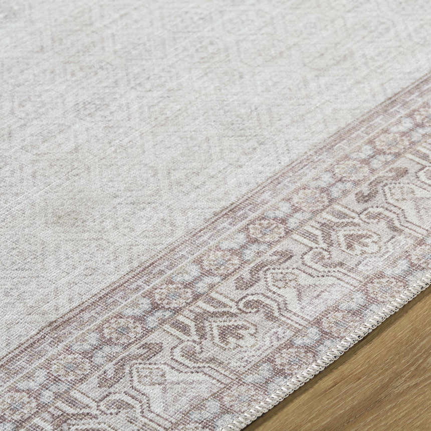 Close-up of the Rainier Cottage Border Brown Washable Rug showing the cream color and traditional border pattern. Texture
