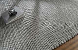 Close-up of the hand woven Cirencester Area Rug in medium gray. Wool and viscose blend with chunky braided texture. Styleshot