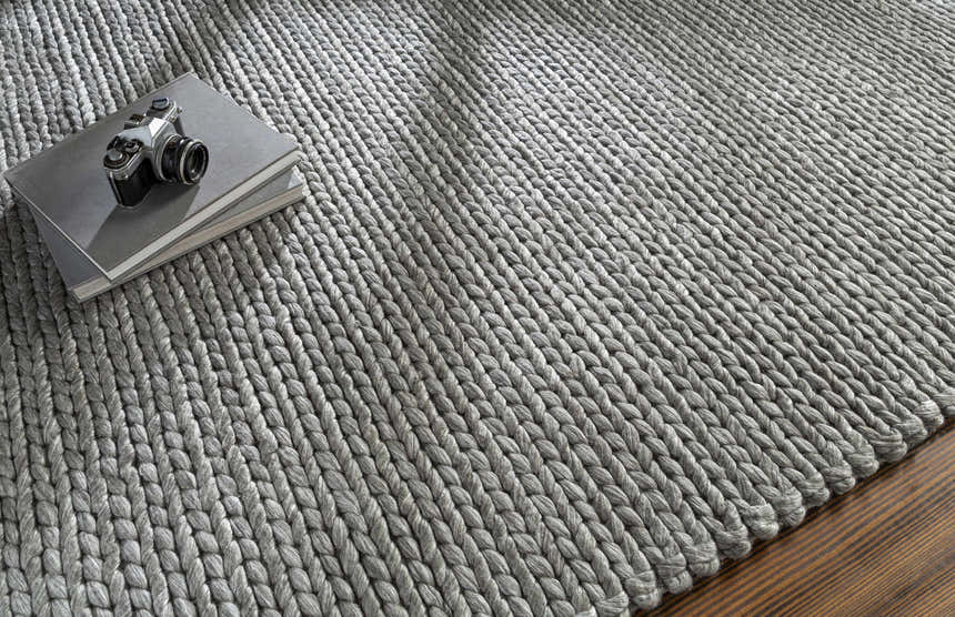 Close-up of the hand woven Cirencester Area Rug in medium gray. Wool and viscose blend with chunky braided texture. Styleshot