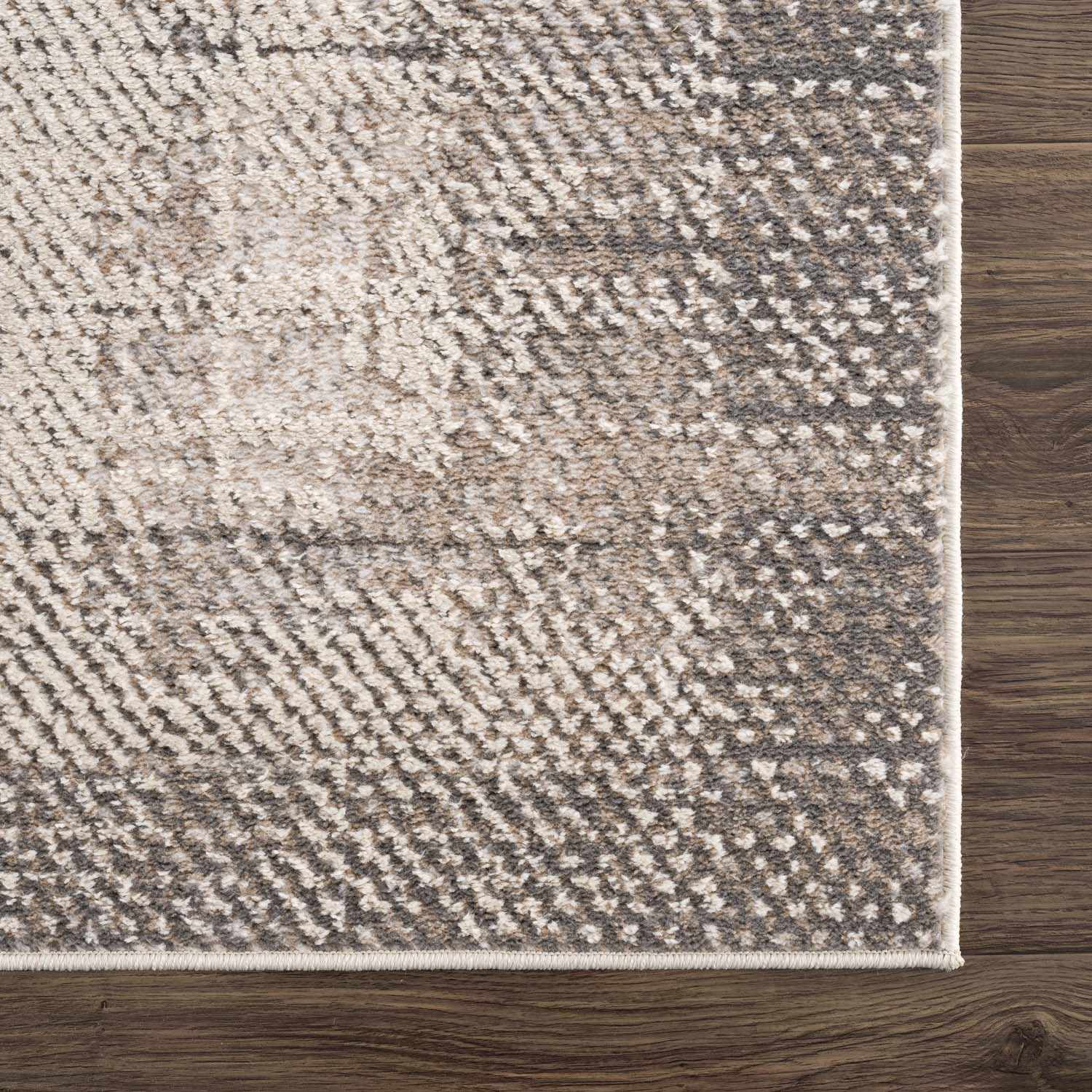 Close-up of Colson Sage area rug showing ash, silver gray, and slate blue tones with a subtle textured pattern. Swatch