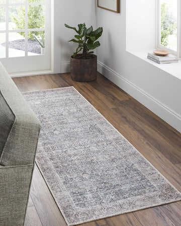Entryway with beige Lorelai runner rug, wood floors, and a gray sofa. Roomscene-Runner