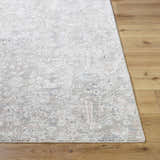 Close-up of the Carlyn Area Rug. Cream rug with light sage, tan, and light slate floral pattern on hardwood floor. Front