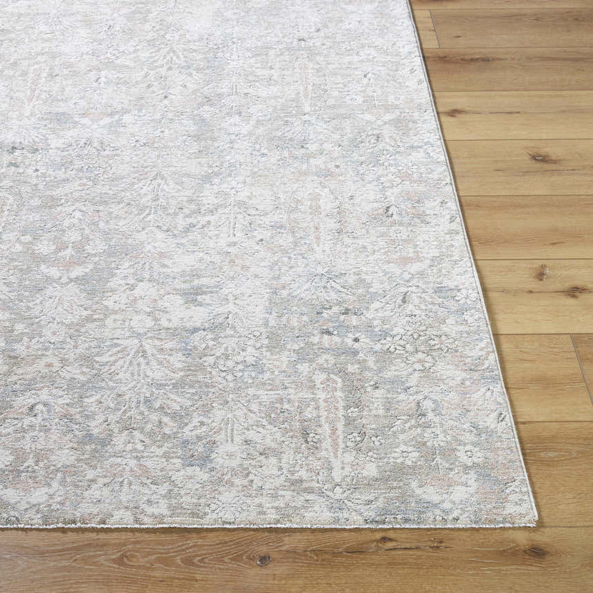 Close-up of the Carlyn Area Rug. Cream rug with light sage, tan, and light slate floral pattern on hardwood floor. Front