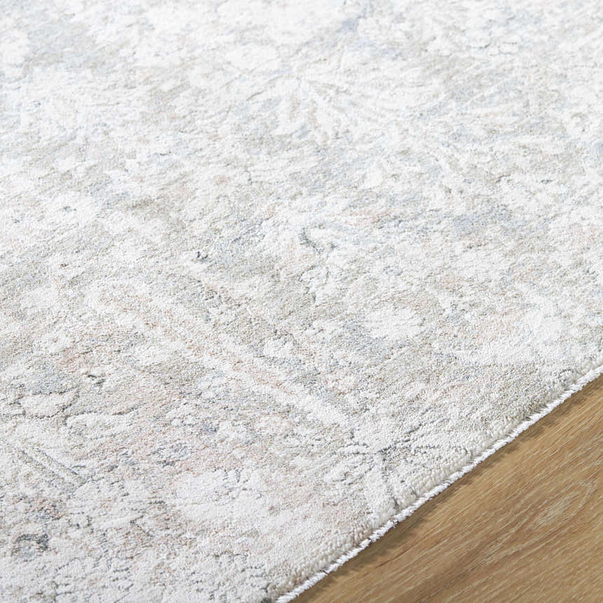 Close-up of the Carlyn Area Rug. Cream rug with light sage, slate, and tan traditional pattern. Soft texture. Texture