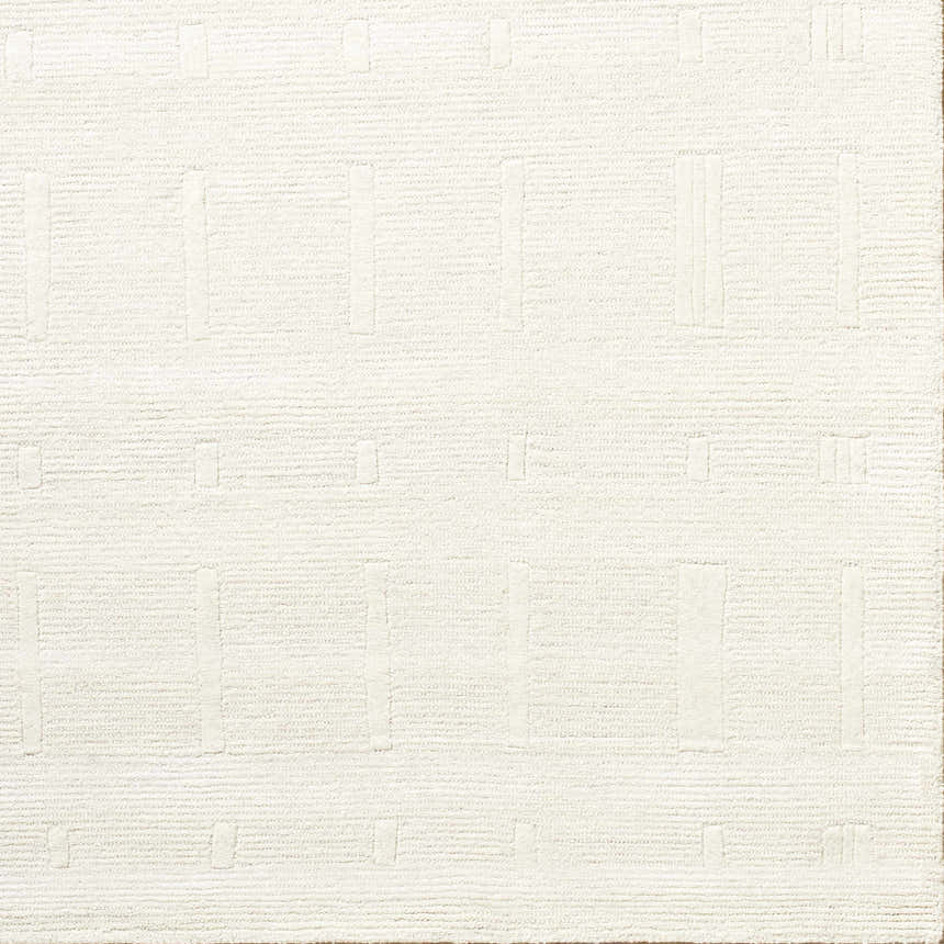 Close-up of a hand-tufted Charan Ivory Cream area rug with a raised, geometric pattern and textured wool. Corner