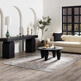 Living room scene with a cream sofa and Abner Washable Area Rug in black, charcoal, and pale pink tones. Roomscene-Rectangle