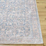 Close-up of the Lorelai Vivir x LIVABLISS rug. Machine woven rug with dark red, denim, light sage, tan, and teal traditional pattern. Front