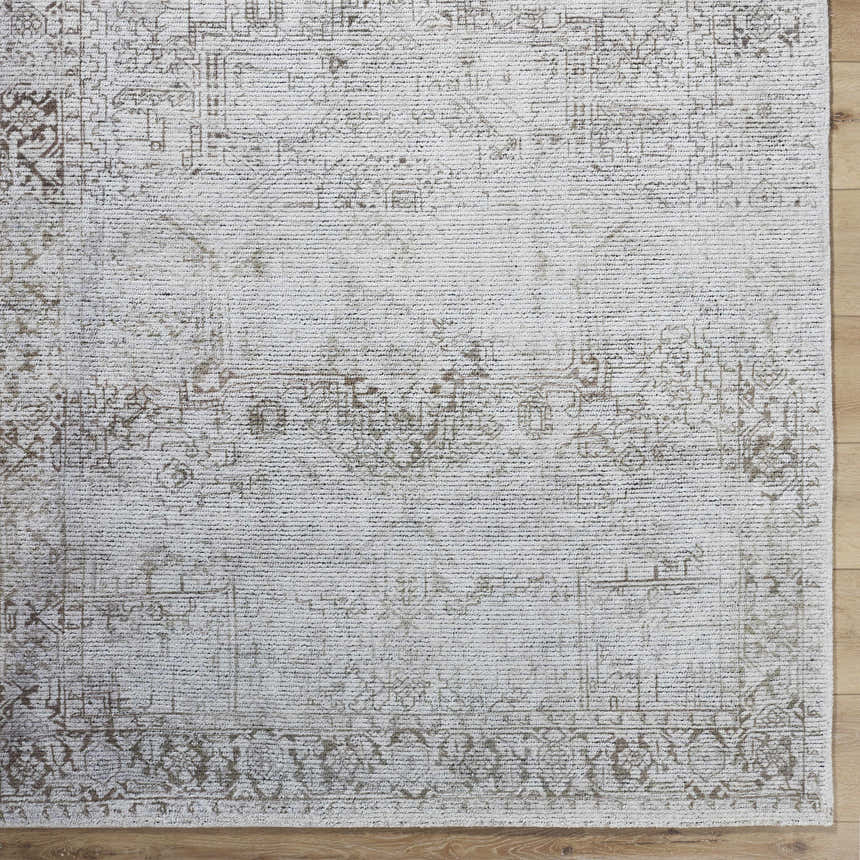 Close up of the hand tufted Clodia Area Rug, showcasing its charcoal, ivory, and taupe traditional pattern. Swatch