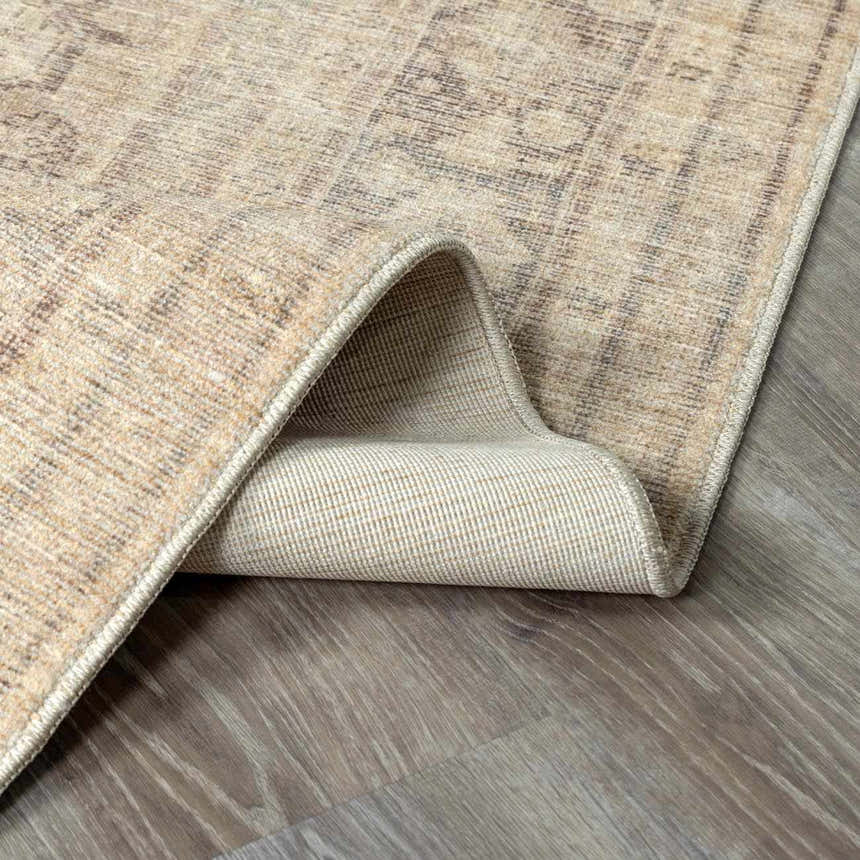 Close-up of the Fetscher V Vintage Damask Area Rug showing its tan, ivory, and gray tones and vintage-inspired pattern. Fold