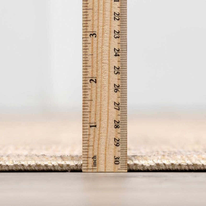 Close-up of Fetscher V Vintage Damask Area Rug pile height with a ruler showing it's less than 1 inch thick. Pile