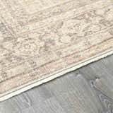 Close-up of the Fetscher V Vintage Damask Area Rug showing its tan, ivory, and gray damask pattern and fringed edge. Corner