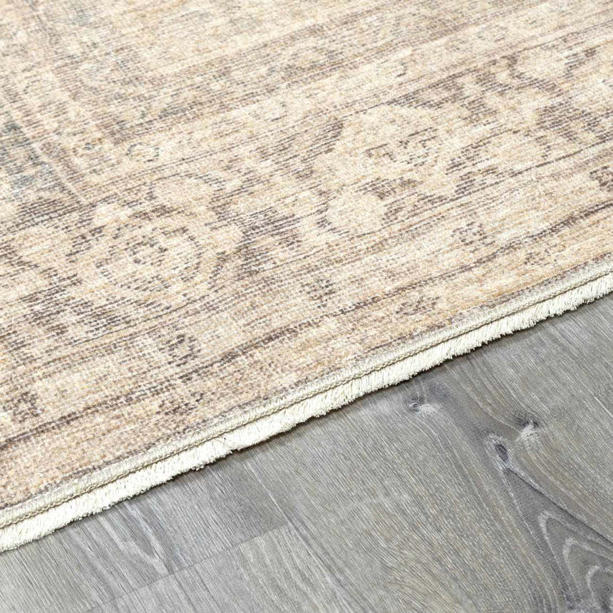 Close-up of the Fetscher V Vintage Damask Area Rug showing its tan, ivory, and gray damask pattern and fringed edge. Corner