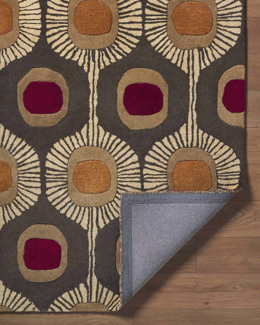 Close-up of the Canovanas Modern Wool Rug with a brown, burgundy, and tan floral pattern on a gray background. Fold