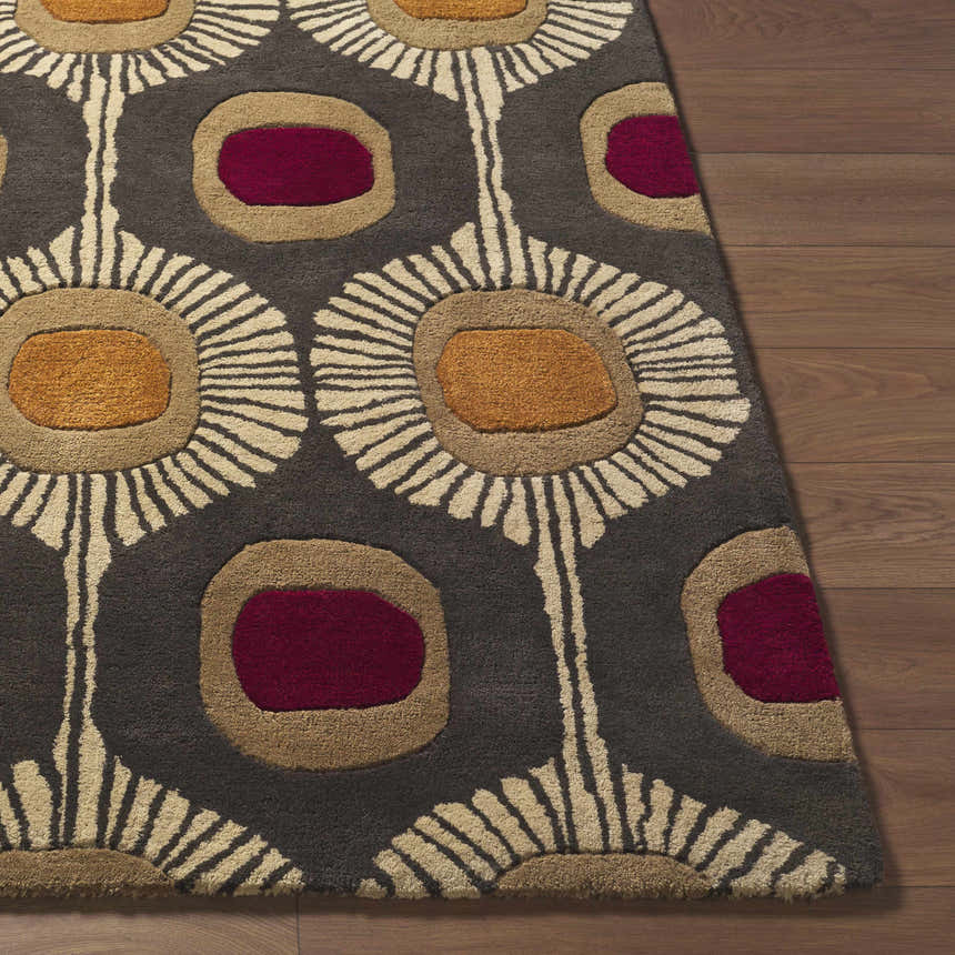 Close-up of the Canovanas Modern Wool Rug, featuring a floral pattern in brown, burgundy, tan, and dark brown on a wood floor. Front