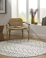 Sunlit reading nook with a round Scandi Moroccan Trellis Rug, woven chair, and wood accents. Roomscene-Round