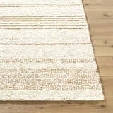 Close up of the hand woven Ciaran Area Rug, showcasing its ivory and sandstone stripes and wool texture. Front