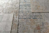 Close-up of the Runa Area Rug, showcasing its contemporary design, blue, brown, and off-white colors, and machine-woven texture. Styleshot