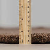 Close-up of the pile height of the hand-tufted Chogan Chocolate Brown Area Rug, made of 100% wool. Pile