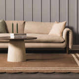 Living room scene with a Chogan Chocolate Brown Area Rug, beige sofa, and round coffee table. Roomscene-Rectangle