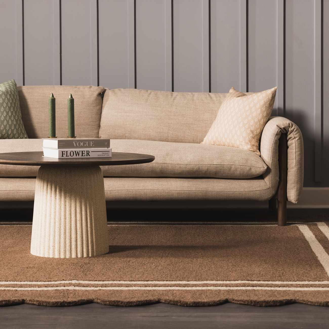 Living room scene with a Chogan Chocolate Brown Area Rug, beige sofa, and round coffee table. Roomscene-Rectangle