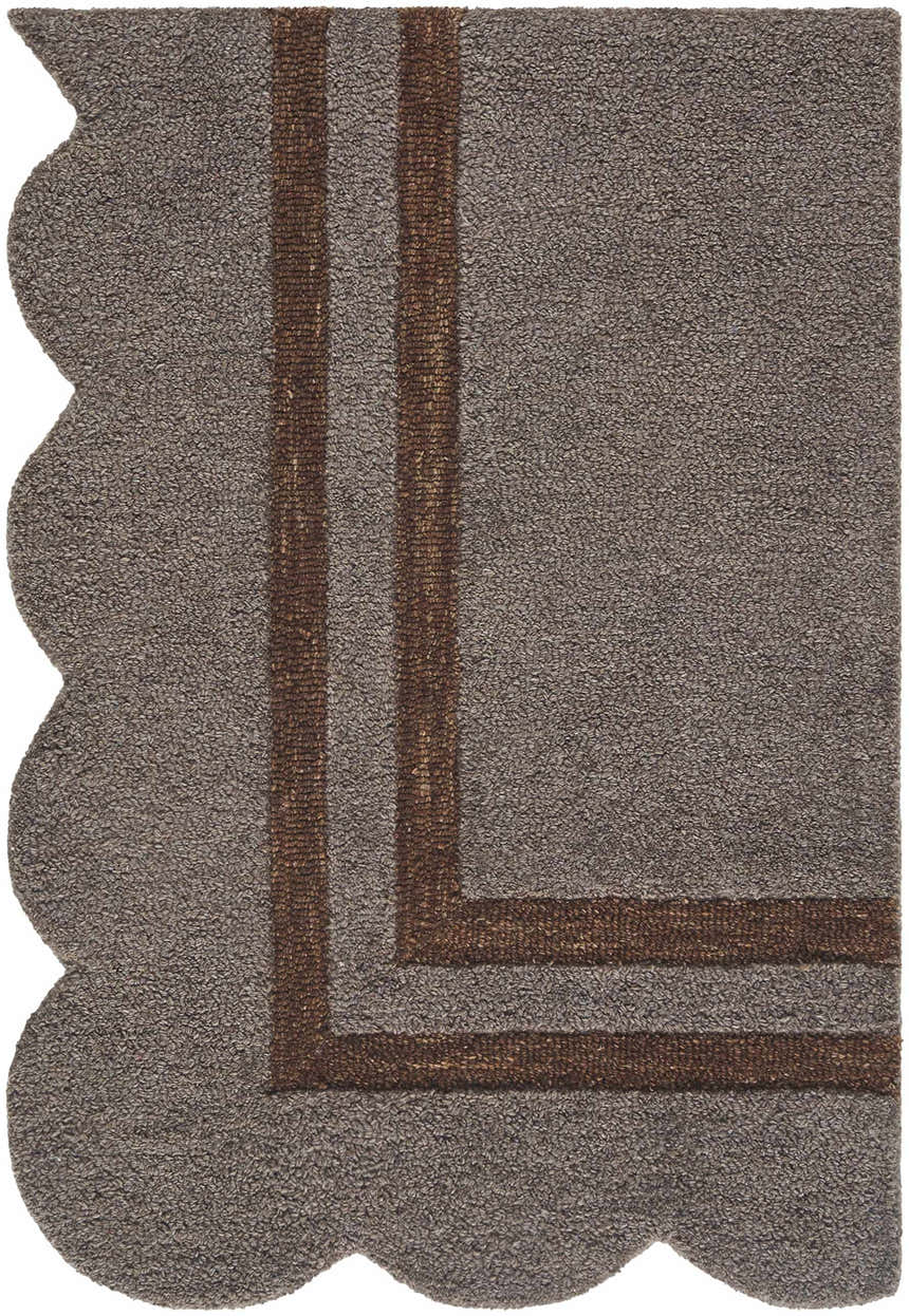 Close-up of the hand-tufted Chogan Charcoal Area Rug. Features a brown border and scalloped edge. 100% Wool texture. Corner