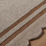 Close-up of the hand-tufted Chogan Charcoal Area Rug showing texture and brown stripes on a wood floor. Texture